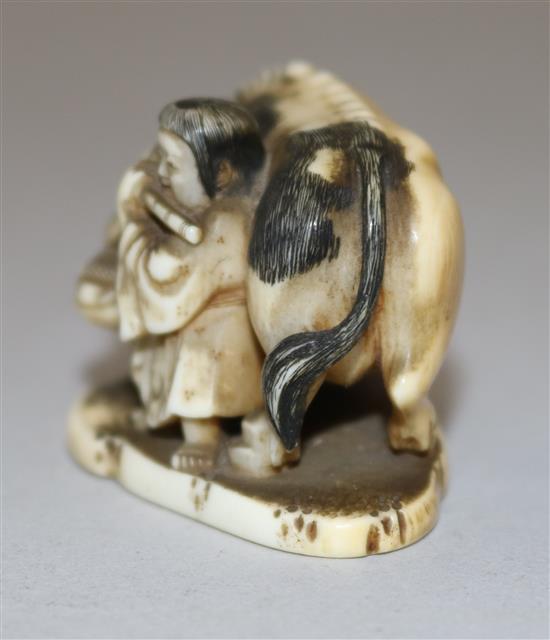 A Japanese ivory netsuke of a figure playing the flute standing by an ox, 19th century, 4.4cm